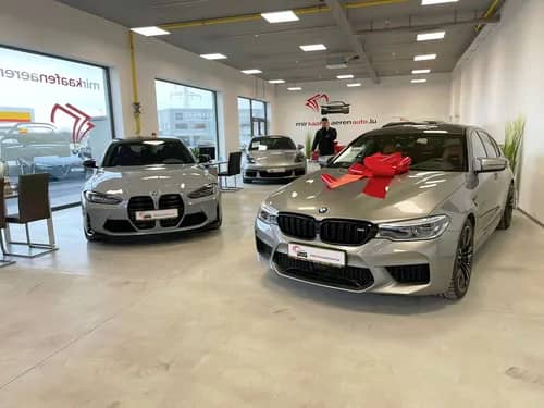 Fahrzeugübergabe bei MKAA - BMW M5 mit roter Schleife